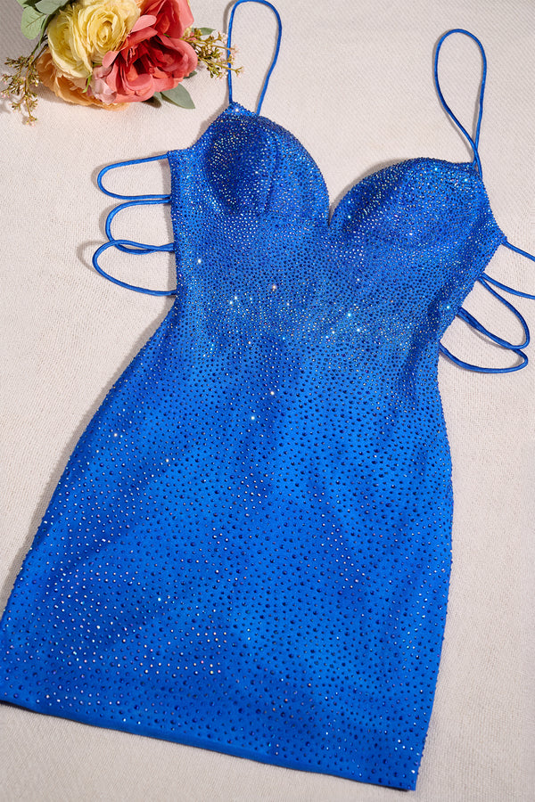 Blue sequin dress on a light background with flowers in the corner